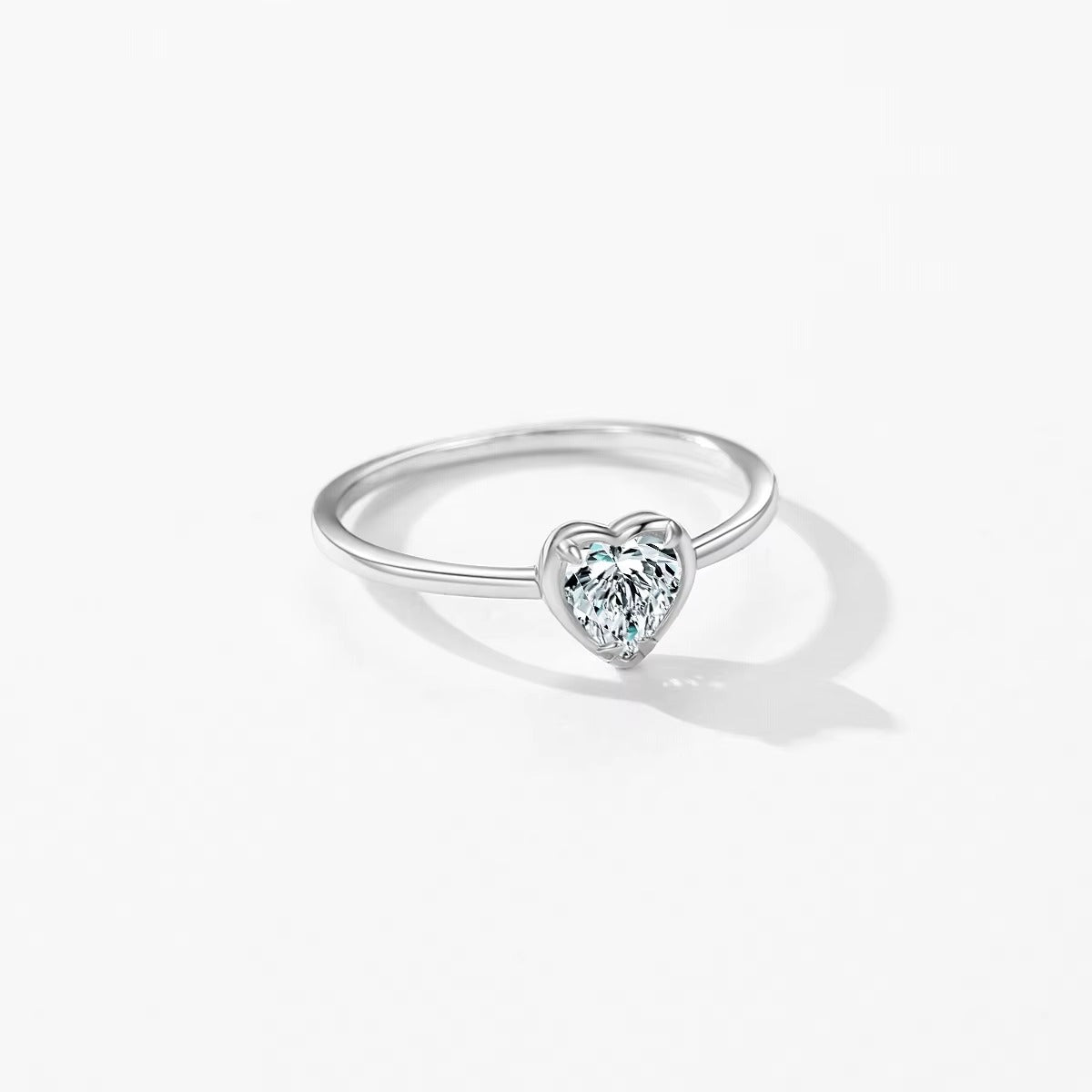 Silver ring with a heart-shaped zircon on a white background