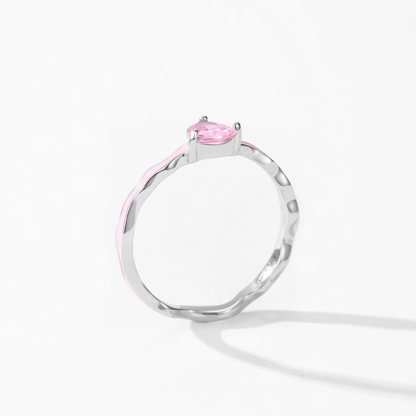 Silver ring with a pink gemstone on a white background