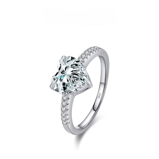 Silver ring with a large heart shaped gemstone on a white background