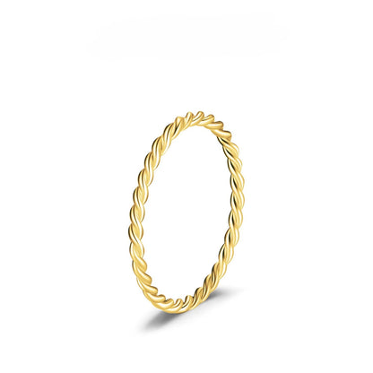 Gold ring with a twisted design on a white background