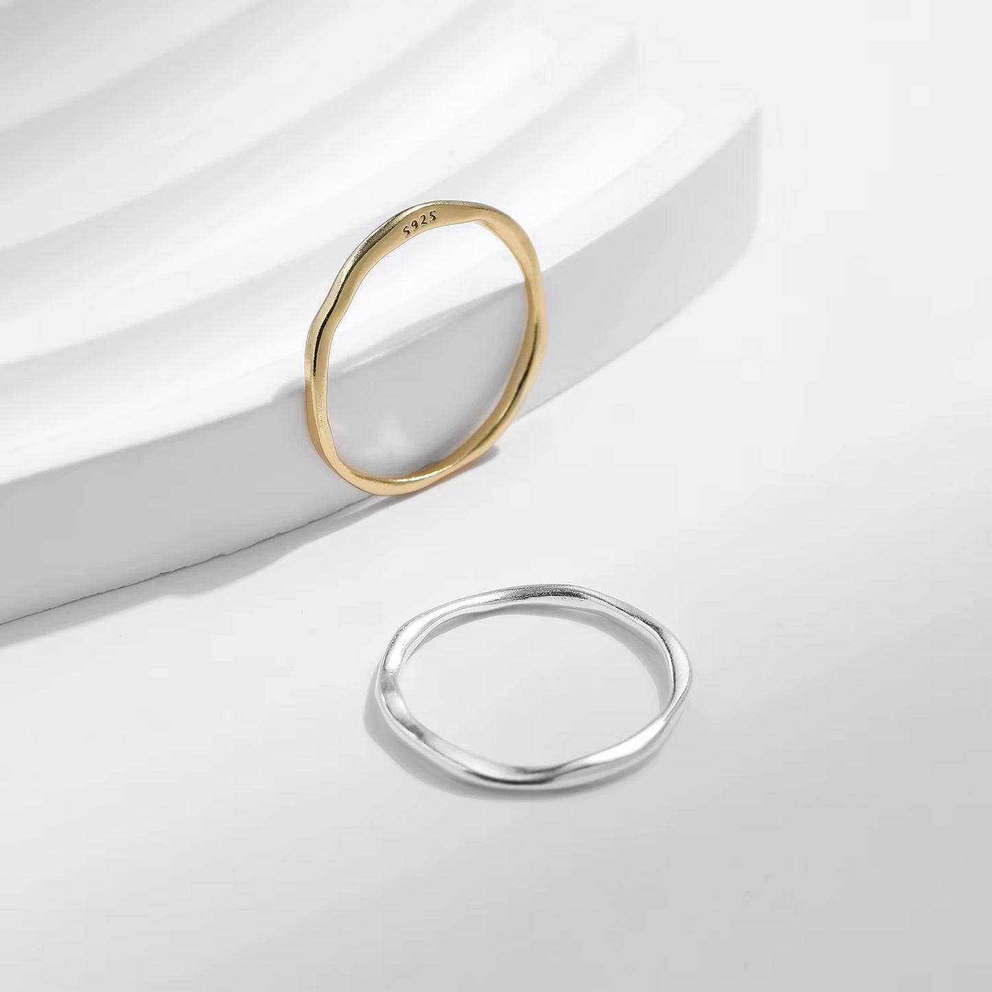 Gold and silver rings on a light gray background