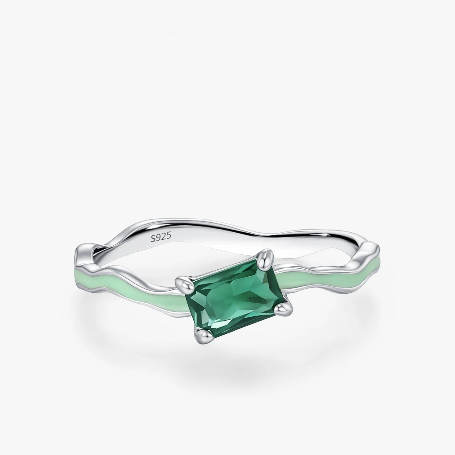 Silver ring with a green gemstone on a white background