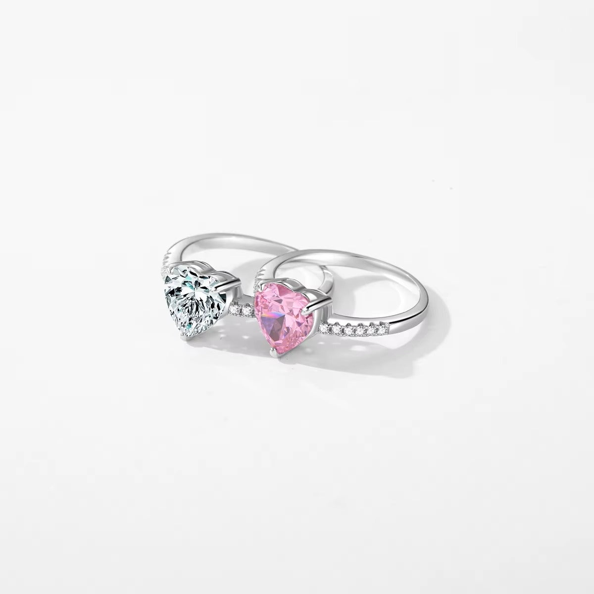 Silver ring with heart-shaped gemstones on a white background