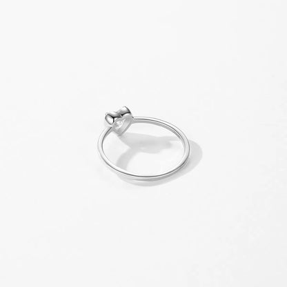 Silver ring with a small zircon on a white background