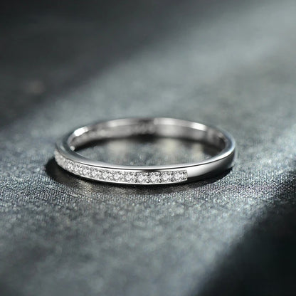 Silver ring with small zircons on a dark textured surface