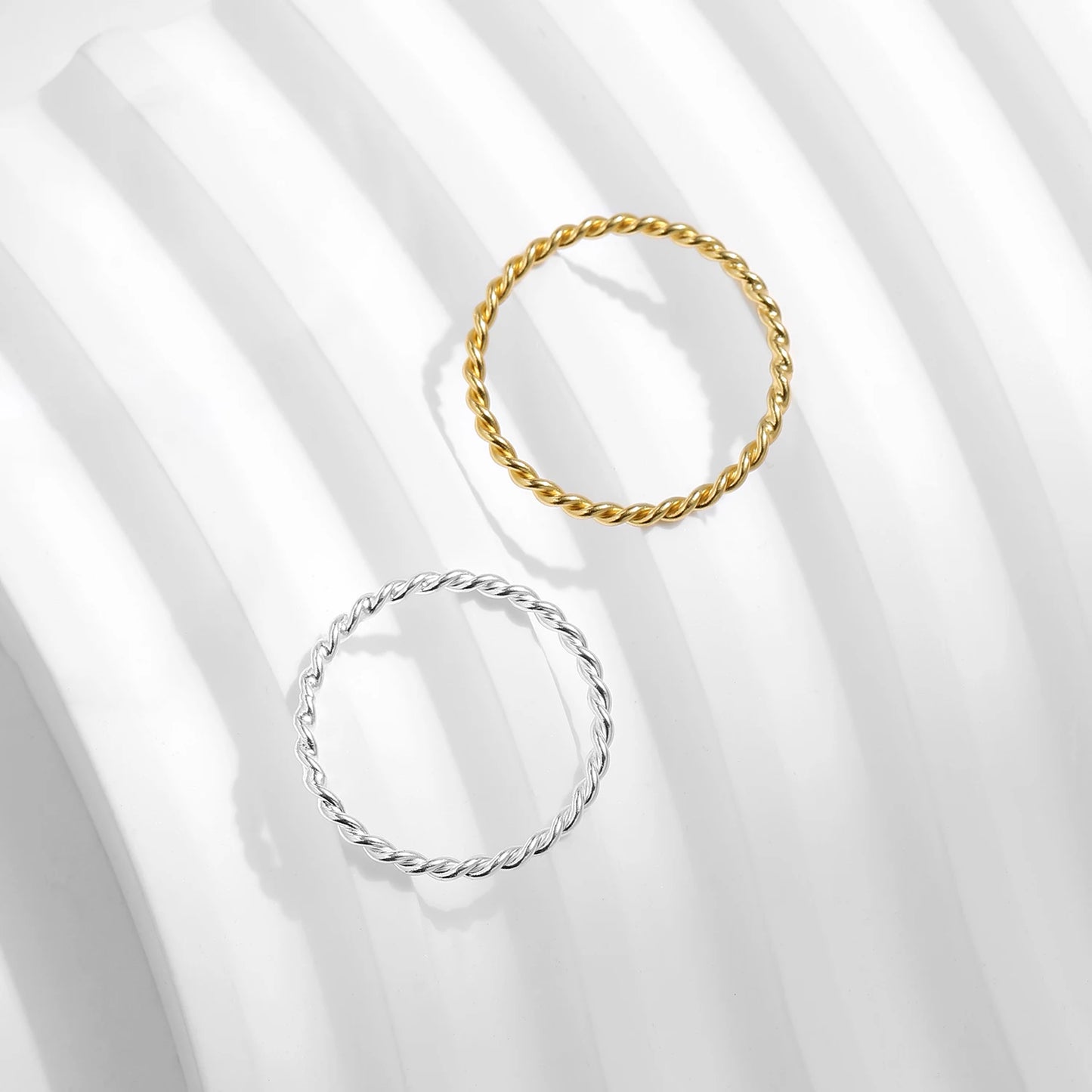Two gold and silver rings on a white fabric background
