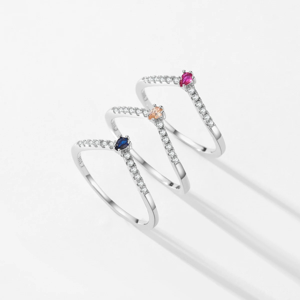 Three silver rings with colored stones on a white background