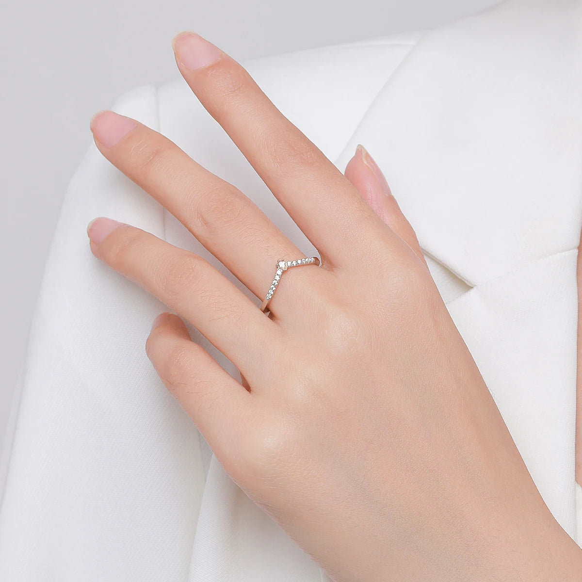Hand wearing a zircon ring on a white background
