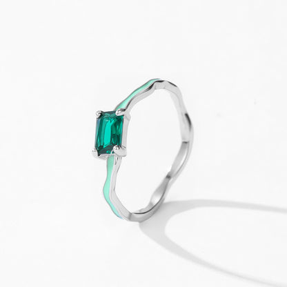 Silver ring with a green gemstone on a white background