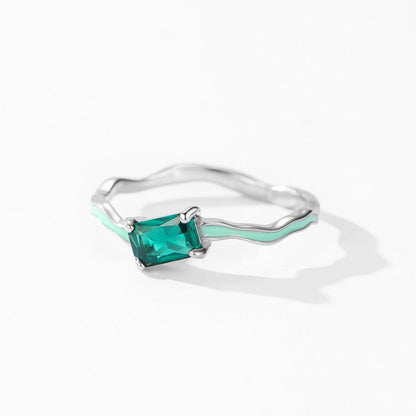 Silver ring with a green gemstone on a white background