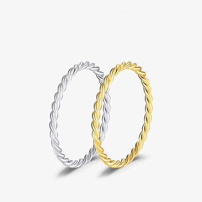 Two twisted rings, one silver and one gold, on a white background