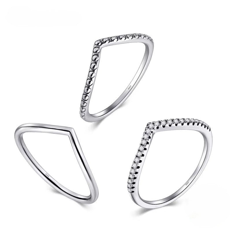 Three silver triangle rings with beaded edges on a white background