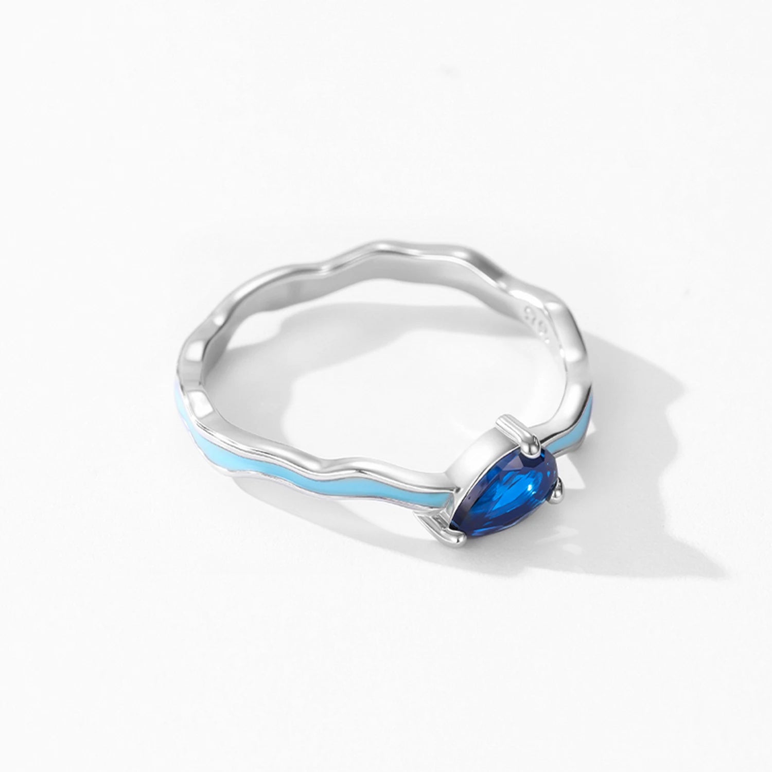 Silver ring with a blue gemstone on a white background