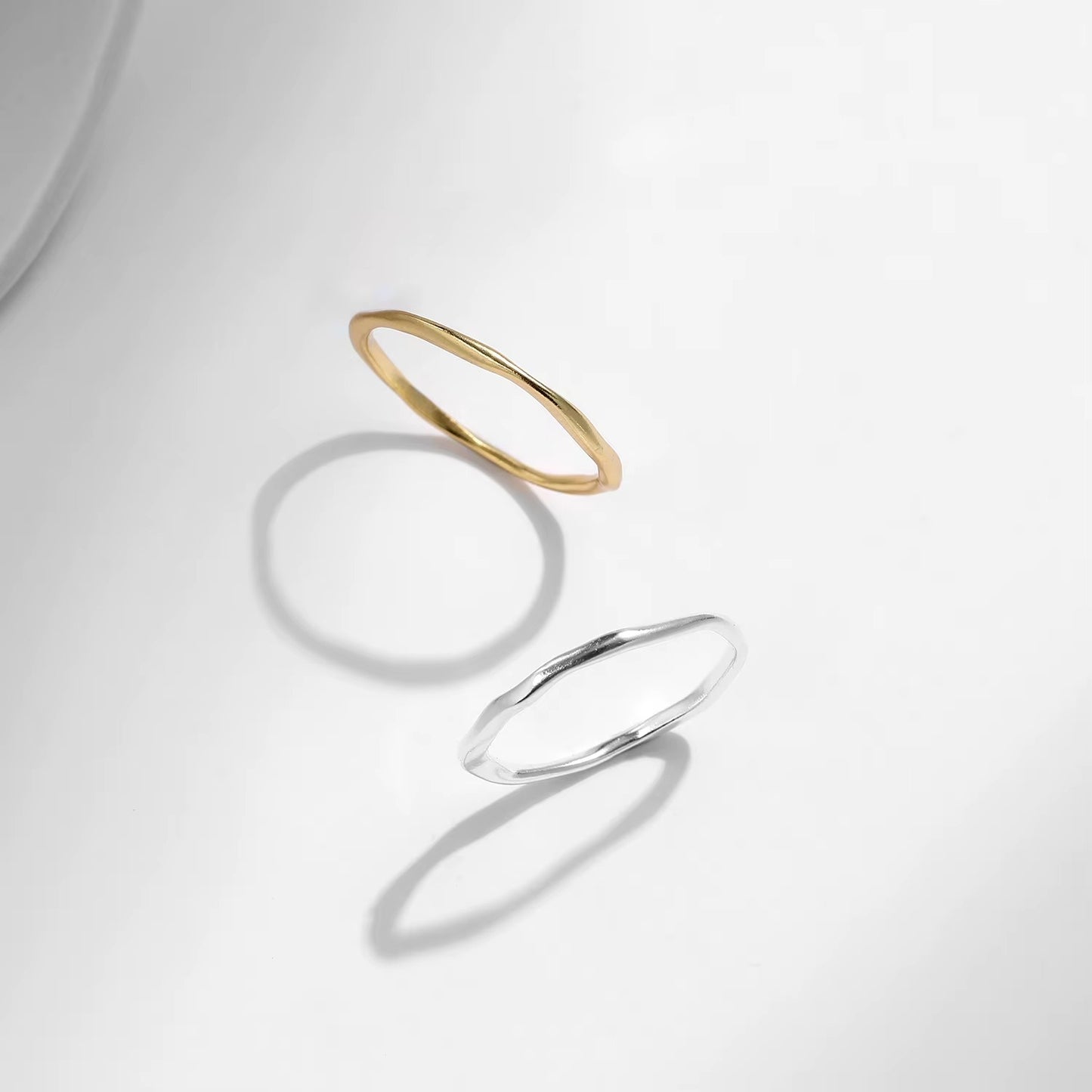 Gold and silver rings on a light gray background