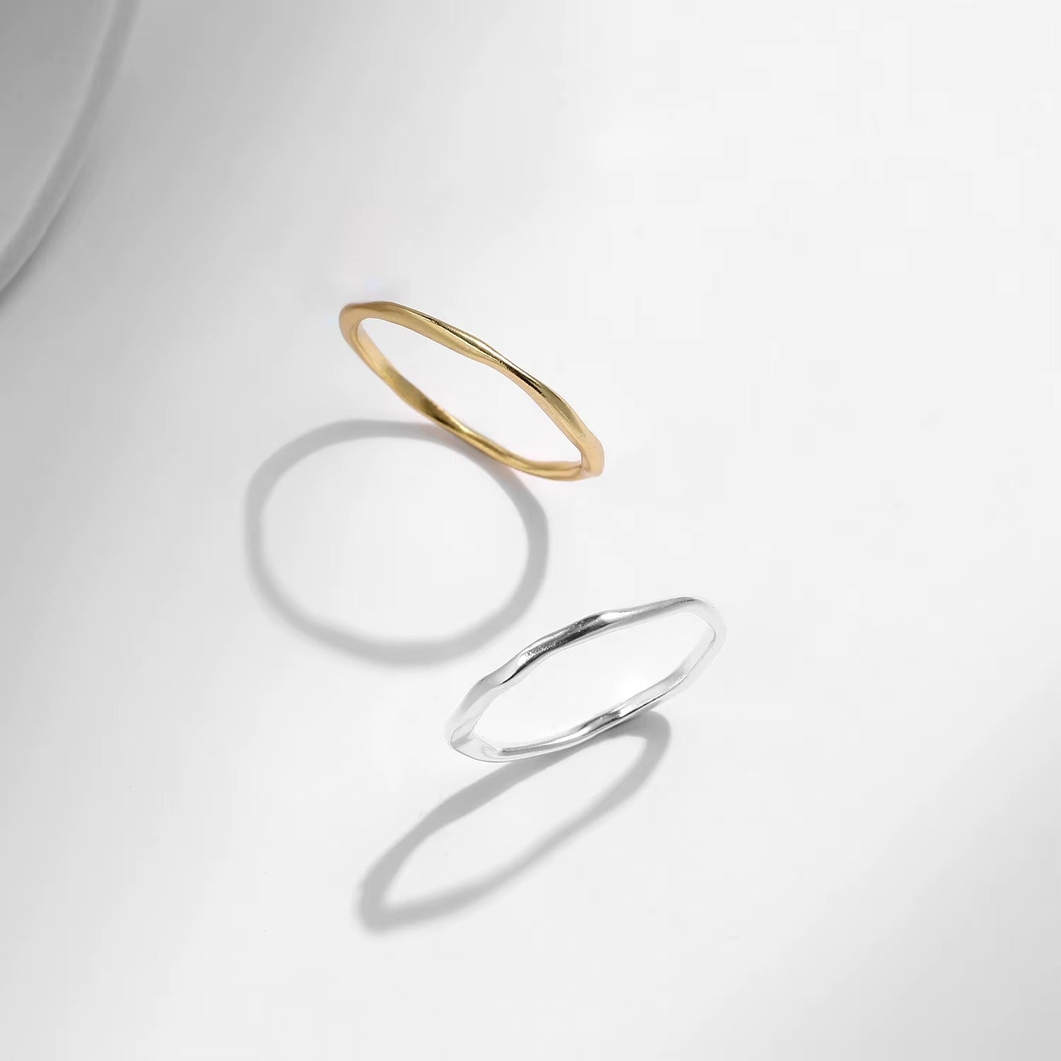 Gold and silver rings on a light gray background